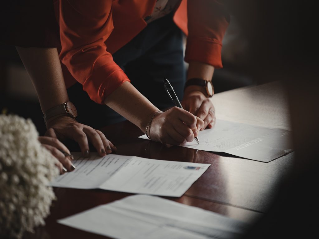 Une personne examine un document sur une table dans le cadre du processus de jumelage client-consultant.