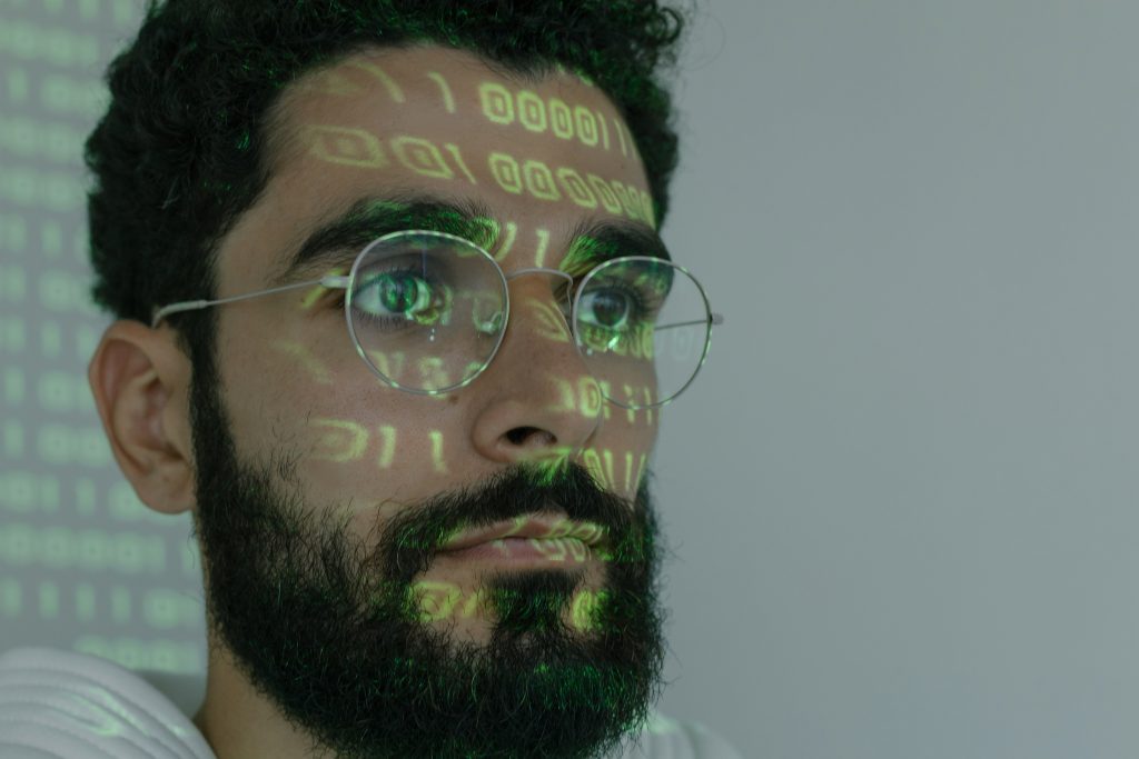 Close up of male with tech coding language projected on his face